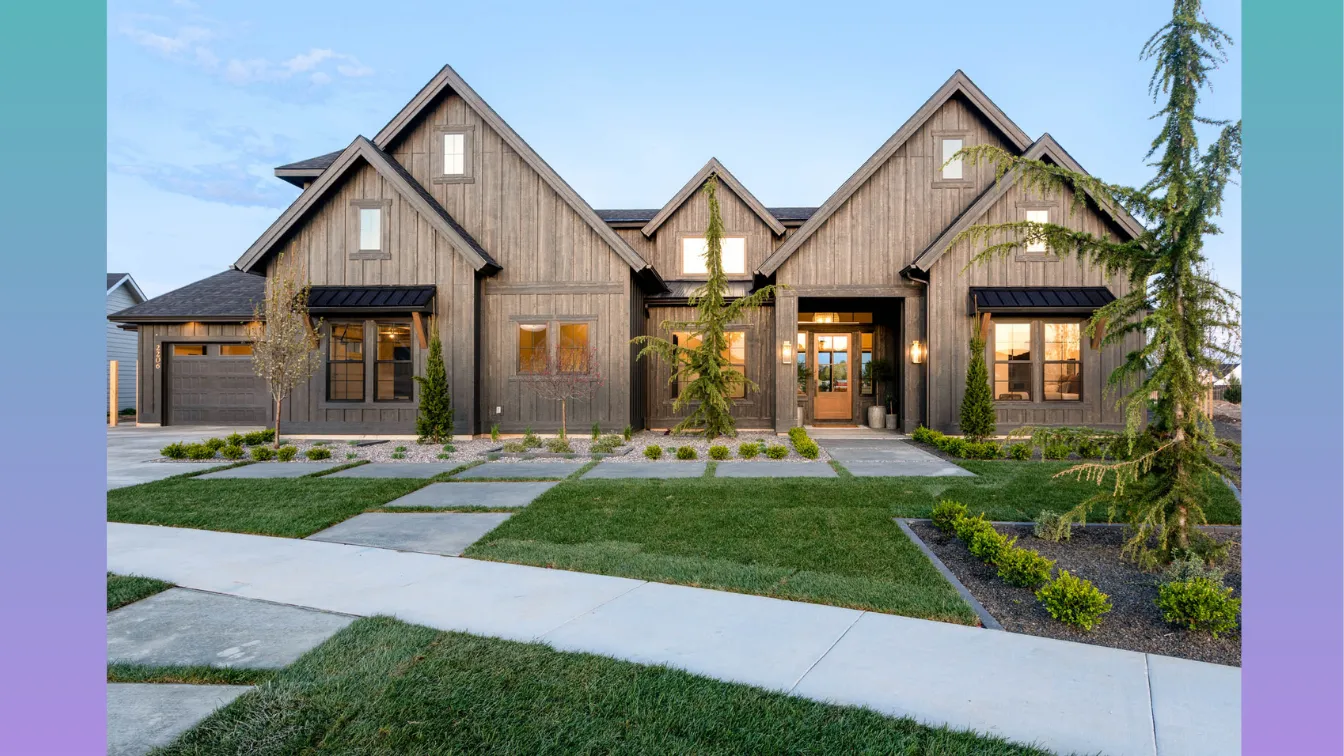 Modern farmhouse-style home built by Alturas Homes, featuring dark wood siding, black metal awnings, and multiple front-facing gables. The home includes large windows, a wood-framed double front door, and professionally landscaped greenery. A clean concrete walkway leads through a manicured lawn. The background features a soft vertical gradient from teal to lavender.